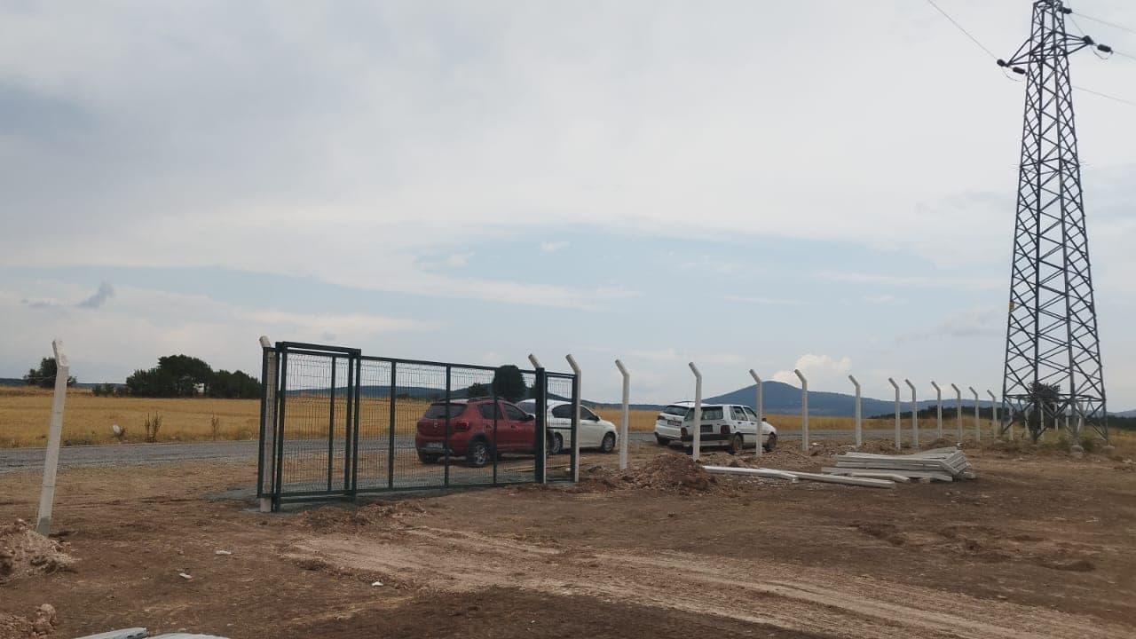 Arazi çevresinde üstüne dikenli tel çekilmiş çit hattı