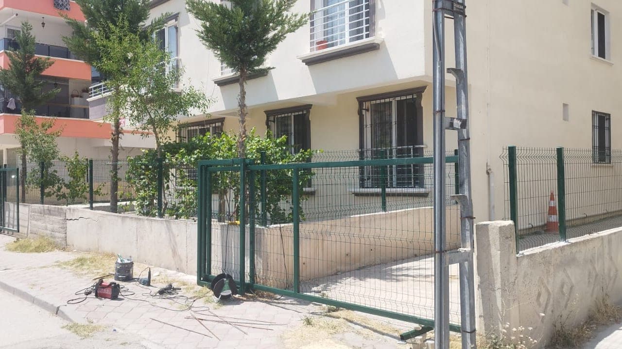 Müstakil ev bahçesi boyunca kurulmuş panel çit hattı