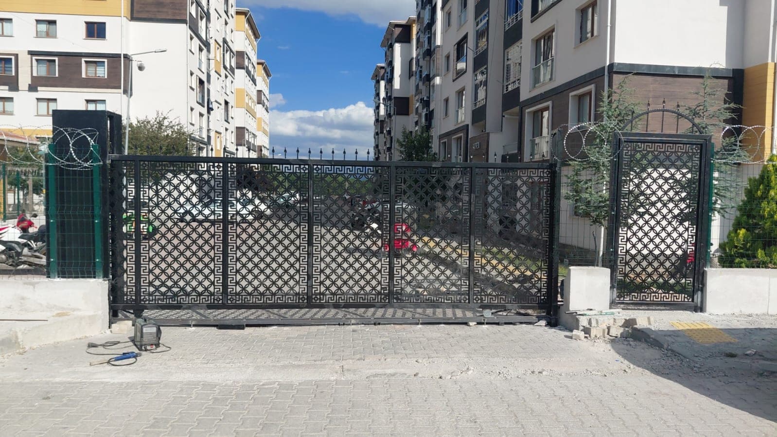 Site girişine monte edilmiş çift kanatlı çit kapısı