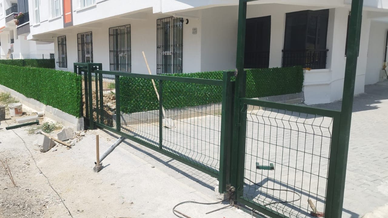Panel çit ve üzerine uygulanan yapay çim perdenin yakın plan görünümü